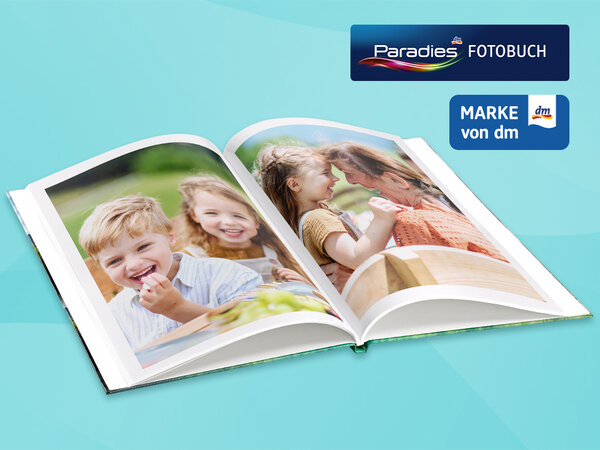 Aufgeschlagenes Fotobuch mit Bildern von lachenden Kindern. Daneben die Logos "Paradies Fotobuch" und "Marke von dm"