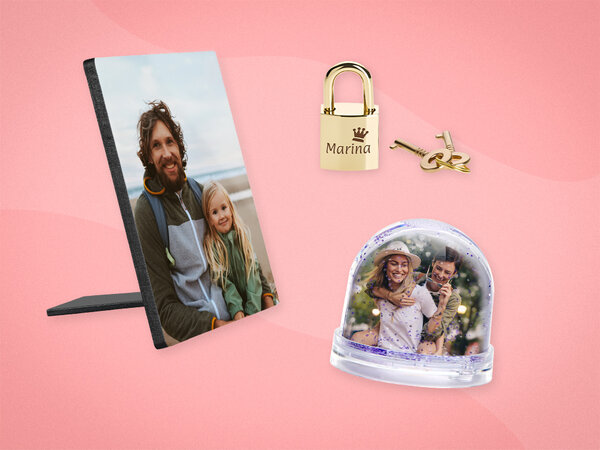 Kleines, goldenes Vorhängeschloss mit Gravur, Fotoaufsteller mit Bild von Vater und Tochter und eine Glitzerkugel mit Foto.